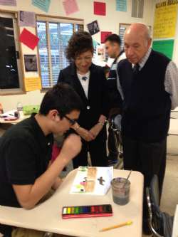 A student explains to Holocaust Survivors Gabriella Karin and David Lenga the theory behind his artwork. 